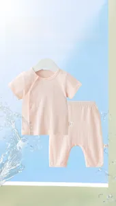 Detail of light pink baby cotton set showing breathable ribbed texture and side ties