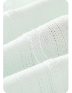 Close-up of mint green knitted ribbed fabric with hollow out texture for baby bodysuits