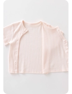 Close-up of light pink infant short sleeve cardigan with breathable jacquard texture