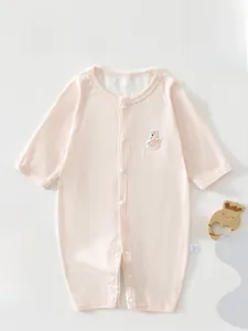 Detail of light pink baby romper showing ribbed fabric texture and swan embroidery