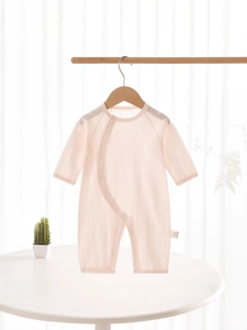 Pink cotton long sleeve baby romper in lightweight breathable fabric on wooden hanger