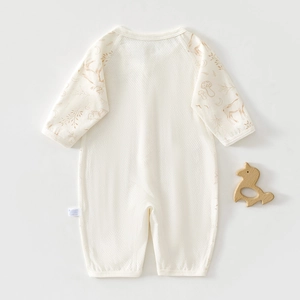 Close-up of breathable mesh cotton fabric on baby long sleeve bodysuit with forest print