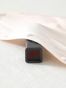 Close-up of baby bodysuit fabric showing zero formaldehyde safety test on a digital meter
