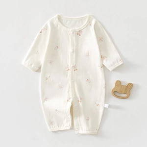 Close-up of the cherry and bow print on this soft cotton baby long sleeve romper suit