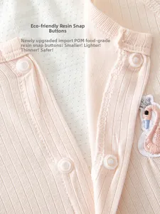 Close-up of baby romper with POM food-grade resin snaps and elegant swan embroidery