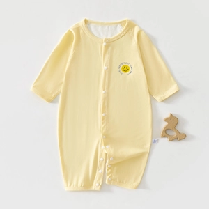 Close-up of pale yellow breathable baby romper with smile logo and front snap buttons