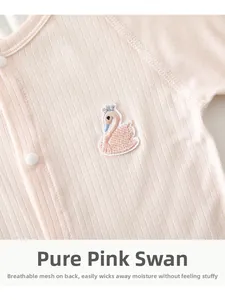 Detail of pink baby romper featuring swan embroidery and breathable mesh back panel
