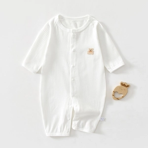 Detail of white cotton baby romper with bear embroidery and vertical ribbed texture
