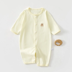 Close-up of baby romper waffle cotton texture with cute brown plush bear patch