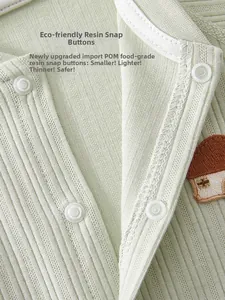 Detail of baby cotton romper showing safe resin buttons and soft ribbed knit fabric