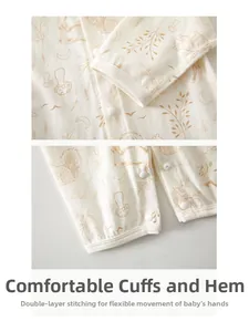 Detail of baby cotton romper with forest prints showing soft cuffs and secure button closure