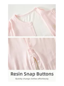 Detail of pink baby romper featuring secure resin snap buttons and soft cotton neckline