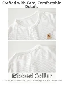 Macro shot of cotton baby romper collar with cute bear patch and snap button closure