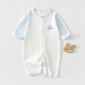 Detail of baby summer romper with waffle texture and small whale embroidery patch