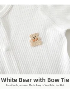 Detail of white infant bodysuit featuring jacquard breathable mesh and bear embroidery