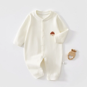 Detail of cream white ribbed cotton baby romper featuring a small house embroidery and snaps