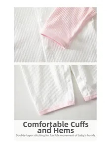 Detail view of baby romper cuffs and leg openings with white resin snap buttons