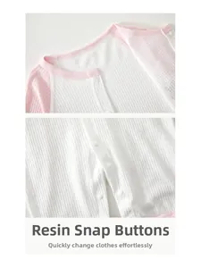 Detail of baby romper featuring resin snap buttons and breathable waffle texture fabric