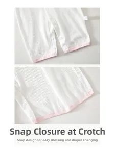 Detail view of snap buttons at the crotch on a thin white baby summer jumpsuit
