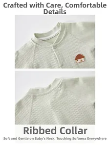 Close-up of baby romper collar and embroidery on soft green ribbed cotton fabric
