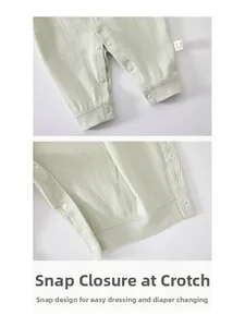 Detail of snap button closure on light green ribbed cotton baby romper for easy diapering