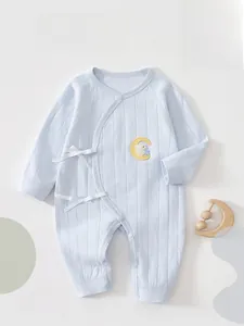 Macro detail of soft cotton light blue baby romper with embroidery and side ties