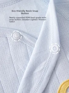 Detailed macro view of eco-friendly POM food-grade resin snaps on cotton baby romper fabric