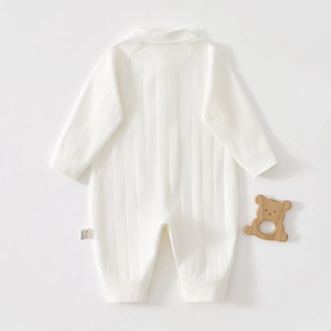 Detailed macro view of white ribbed knit cotton baby romper with cozy texture