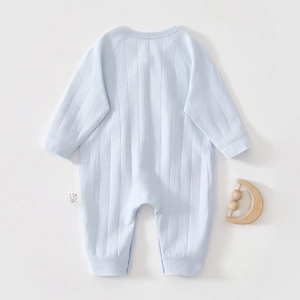 Detail of light blue cotton baby bodysuit showing delicate heart jacquard texture and label