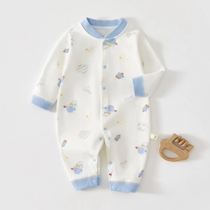 Détail d'un pyjama bébé en coton avec imprimés espace, poignets bleus et étiquette