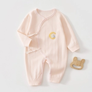 Close-up of pink cotton newborn bodysuit with moon embroidery and ribbon ties