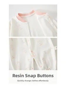 Détail d'un body bébé en coton avec imprimé lapin rose et boutons-pression en résine