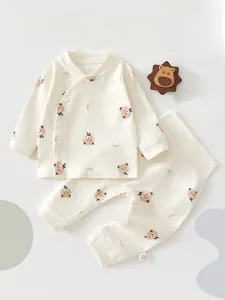 Flat lay of cotton newborn pajama set featuring bear prints and high waist belly protector