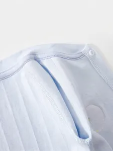 Close-up of light blue cotton baby bodysuit featuring flatlock seams and white resin snaps
