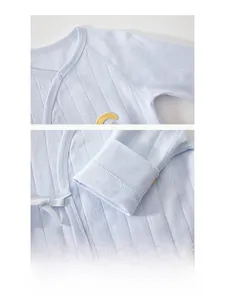 Detailed view of seamless sewing process and button closure on blue baby bodysuit