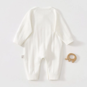 Detail view of white ribbed cotton newborn romper with elastic cuffs and soft knit texture