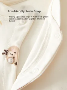 Detail of infant organic cotton jumpsuit with eco-friendly resin snaps and bear pattern