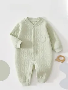 Close-up of quilted light green infant romper featuring soft star and moon textures