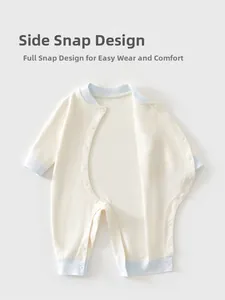 Detail of off-white baby romper with blue ribbing and side-opening snap buttons