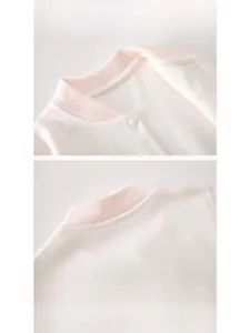 Dettaglio del colletto per neonati con bordo a costine rosa e bottoni automatici in cotone