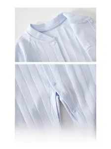 Detail of baby cotton romper showing resin snap buttons and breathable ribbed fabric