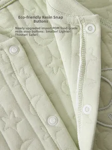 Detail of eco-friendly POM food-grade snaps on light green quilted baby romper