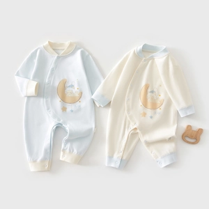 Detailed view of two cotton baby rompers with moon and bear prints in light blue and beige