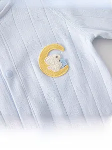 Detail of light blue baby romper with breathable jacquard fabric and bunny embroidery