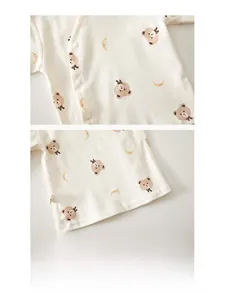 Detail of newborn cotton pajama top with snap buttons and bear patterns