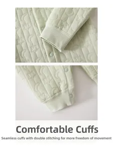Detail of baby romper showing mint green quilted fabric with star pattern and soft cuffs
