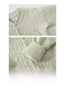 Detailed close-up of seamless stitching and star-quilted pattern on green baby romper