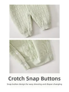 Detail of baby romper snap closure with quilted star moon pattern on green fabric