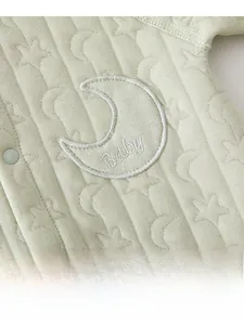 Detail of baby romper featuring moon and star jacquard texture and Baby embroidery
