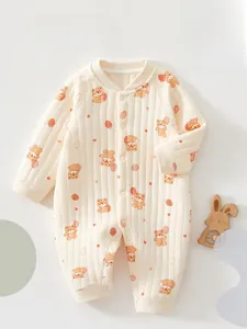 Détail d'une grenouillère matelassée beige pour bébé avec motifs d'ours et fraises
